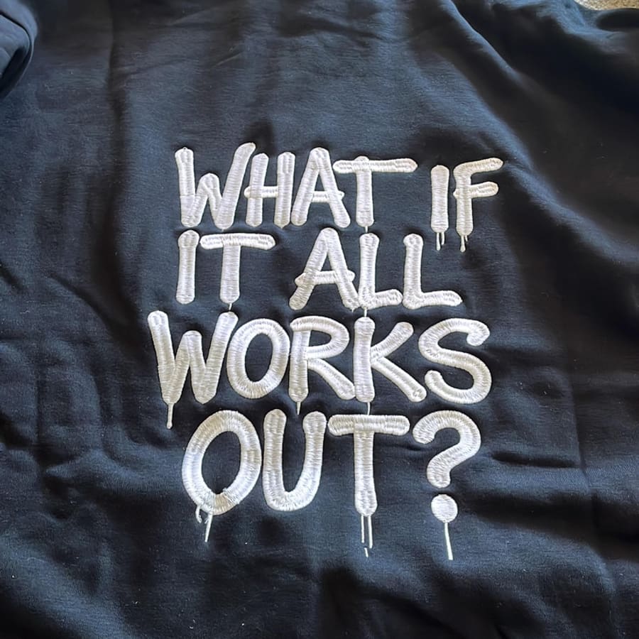 Black hoodie with large embroidered 'What if it all works out?' back design in white lettering