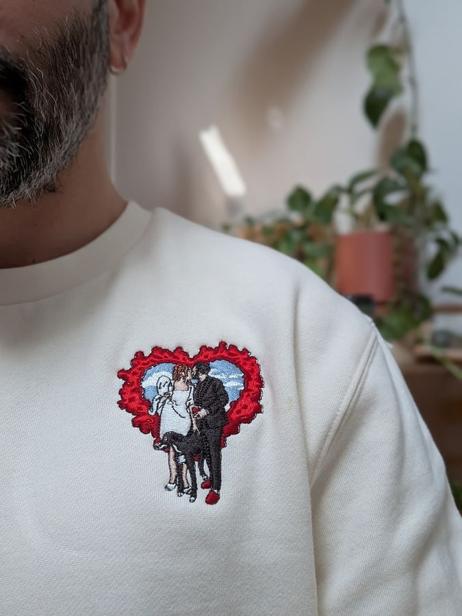 Multi-colour embroidered couple-and-dog flame heart design on a cream sweatshirt